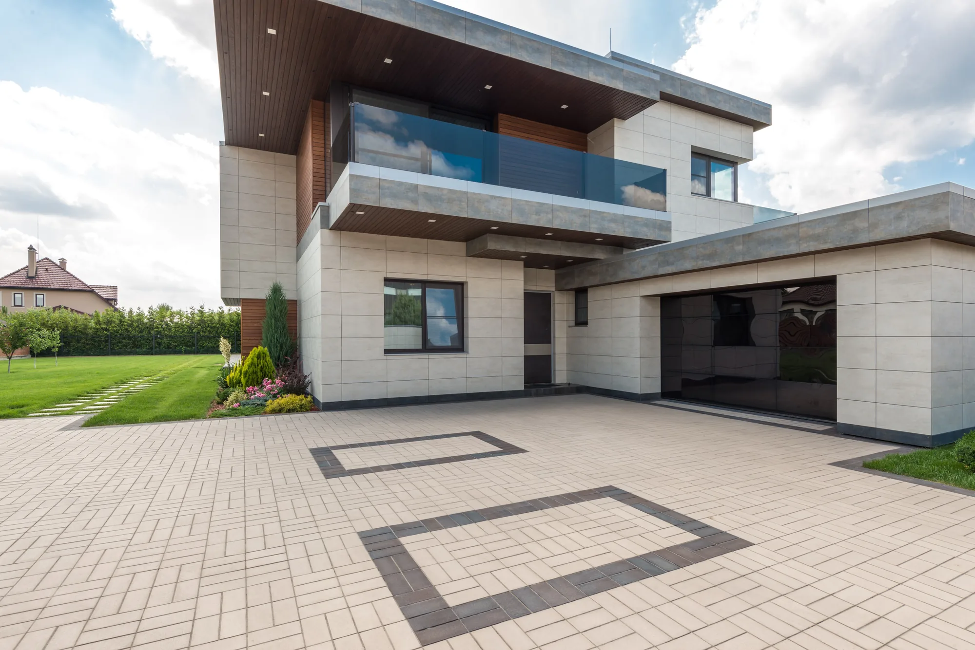 A contemporary house with clean lines opening onto a stone terrace and planted garden