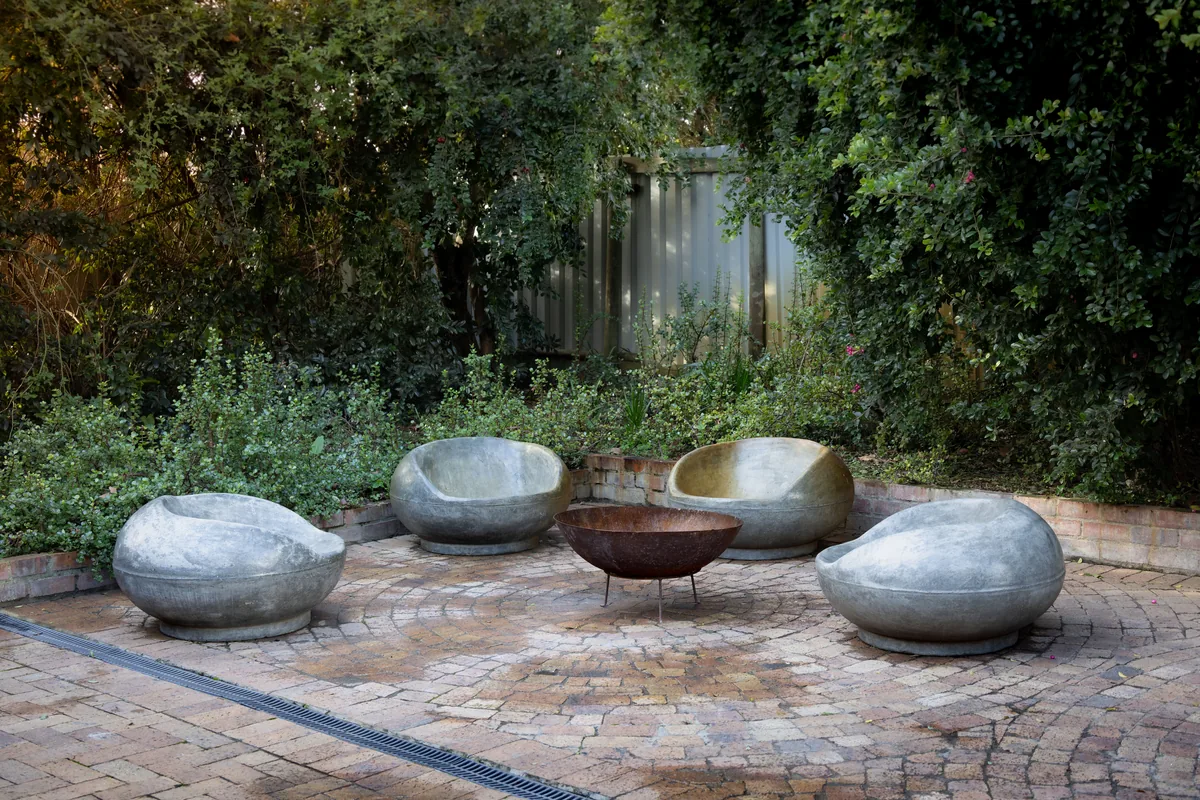 A sunken stone terrace with a fire pit and built-in bench seating